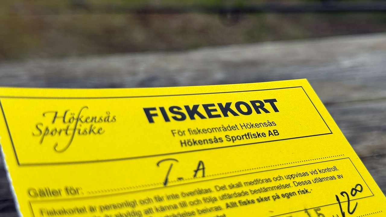 Gul fiskekort från Hökensås Sportfiske, med handskrivna uppgifter på ytan.